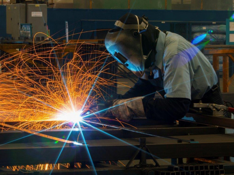 Man welding in a factory with sparks flying
